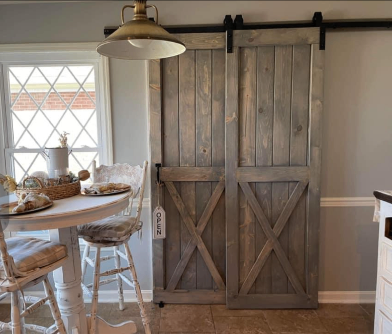 Gray weathered X-brace double barn doors in a farmhouse breakfast nook