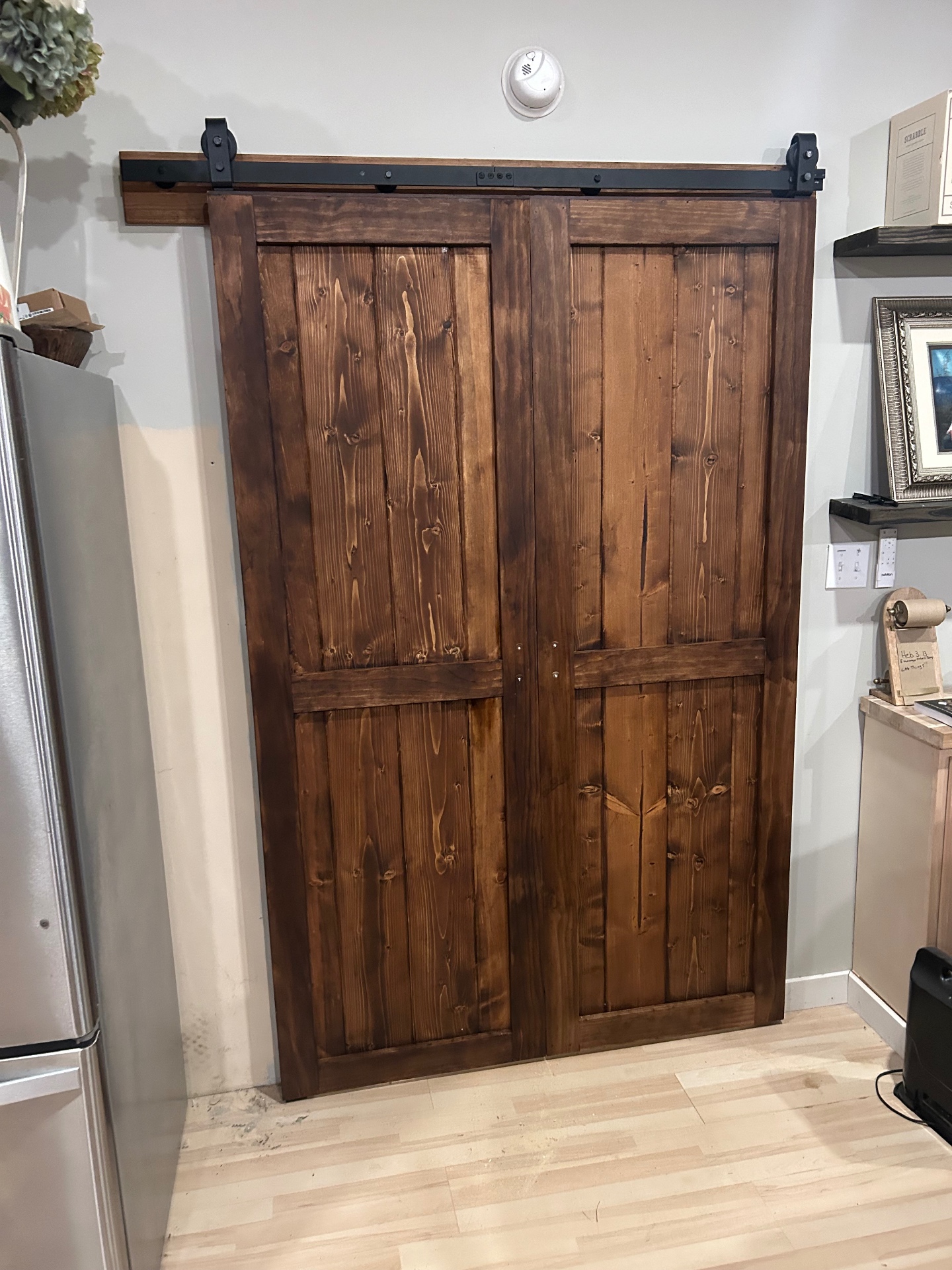 Pair of dark walnut stained double barn doors on a black top-mount rail